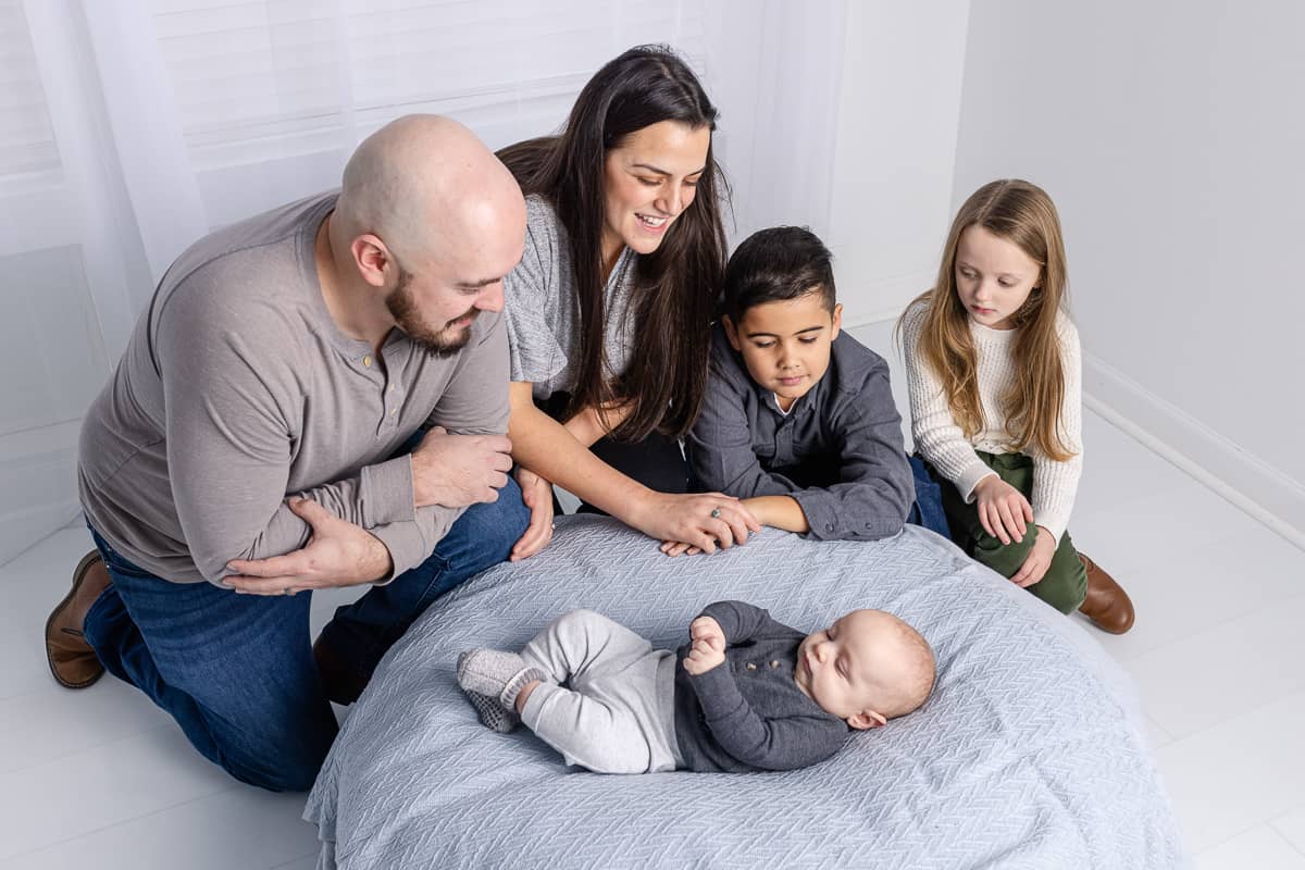 Young family gathers around newborn baby